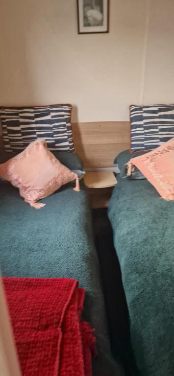 two beds sitting next to each other in a bedroom at 128 Lido Beach in Prestatyn