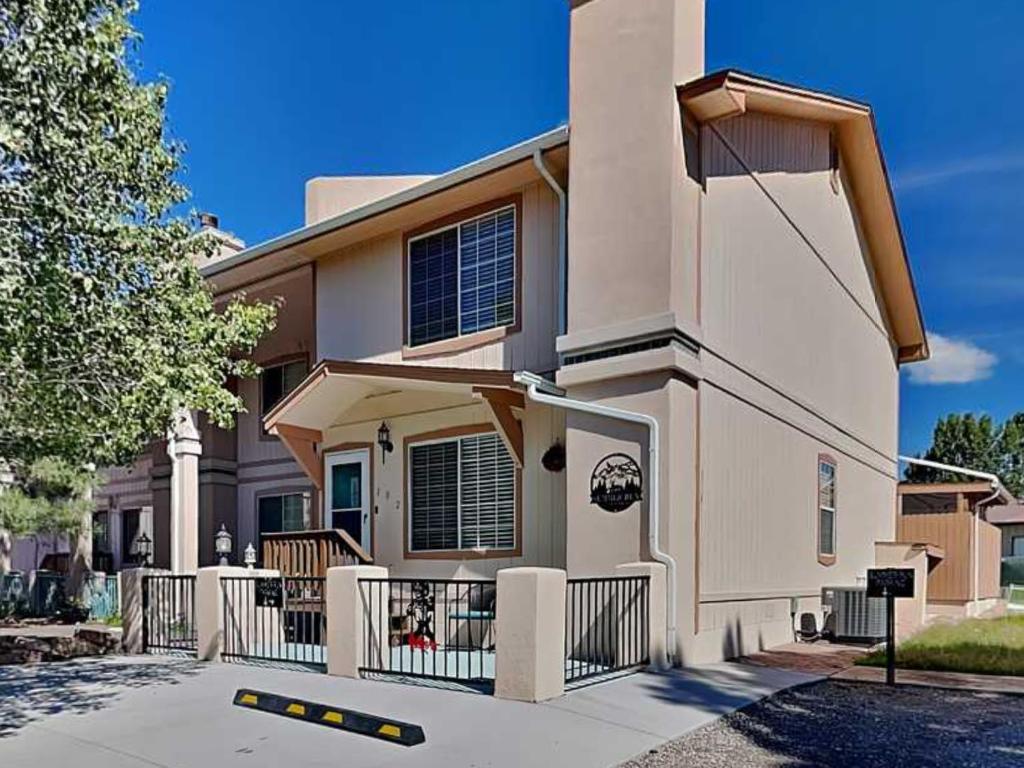 a large house with a fence in front of it at Summer Run in Ruidoso