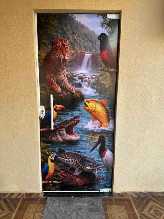 a painting of animals in a river on a wall at Pousada Jangarelli in Guaíra
