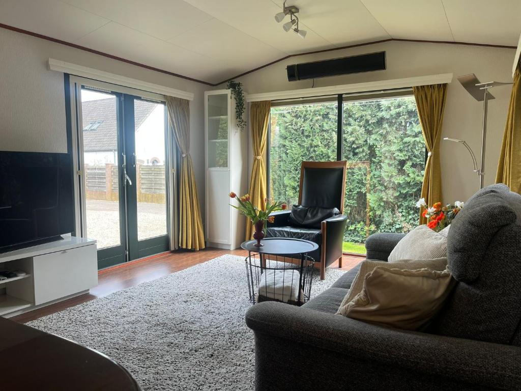 a living room with a couch and a tv at Huisje Weltevree Gendt in Gendt