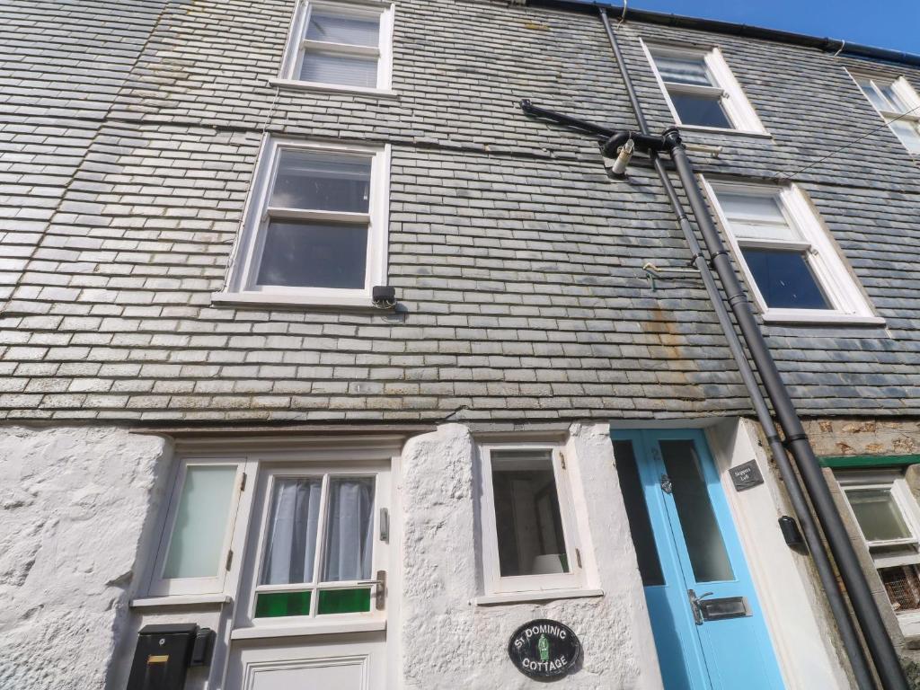 a house with a clock on the front of it at St Dominic Cottage in St Ives
