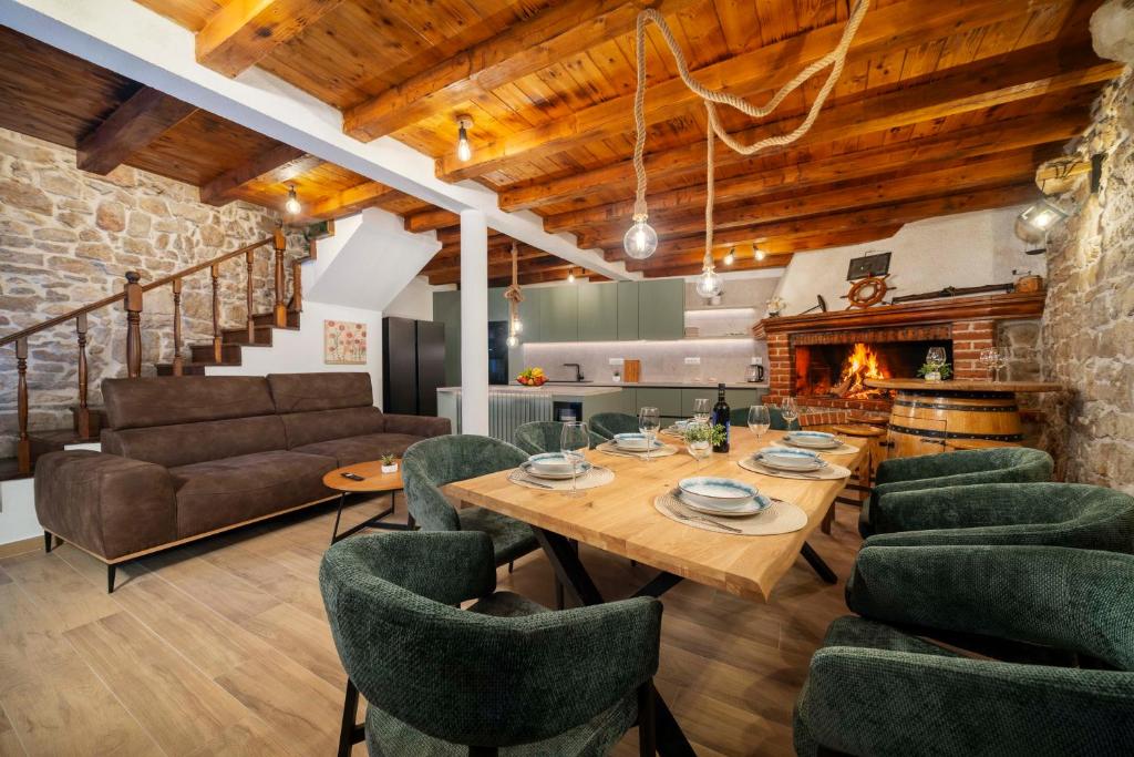 a living room with a table and chairs and a fireplace at Stone House Dida Toni Tribunj in Tribunj