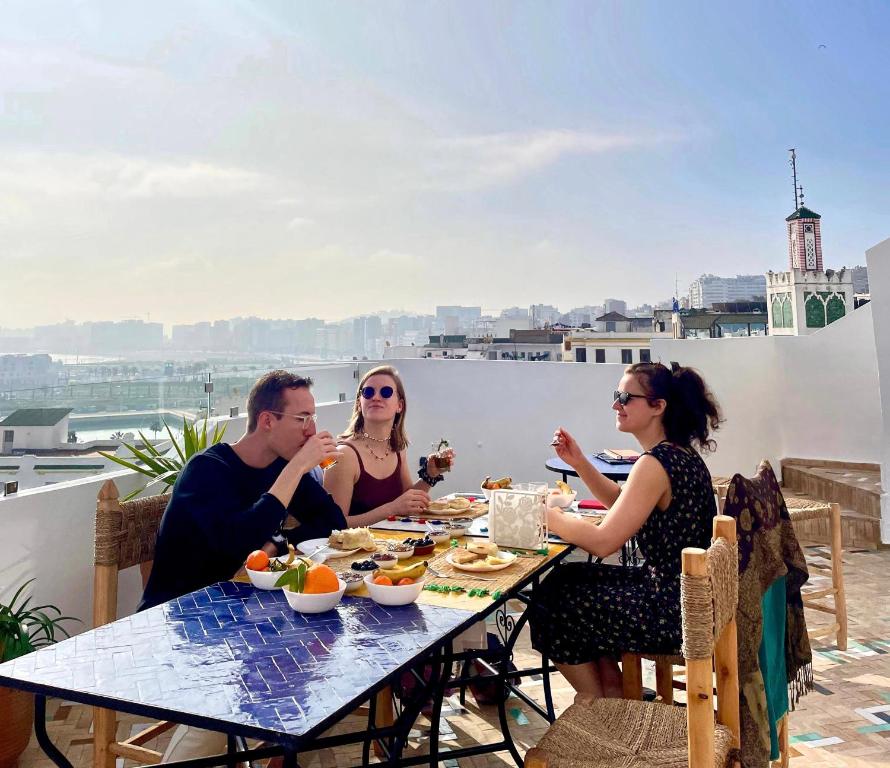 a group of people sitting at a table eating food at Socco Hostel in Tangier