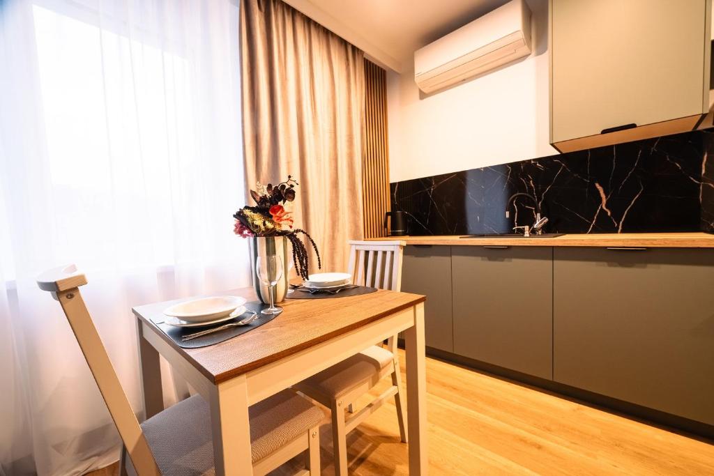 a kitchen with a wooden table and a counter top at ApartHouse in Klimontów