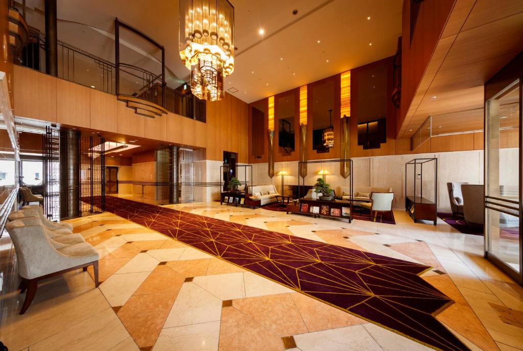 eine große Lobby mit einem Kronleuchter in einem Gebäude in der Unterkunft Royal Park Hotel Takamatsu in Takamatsu