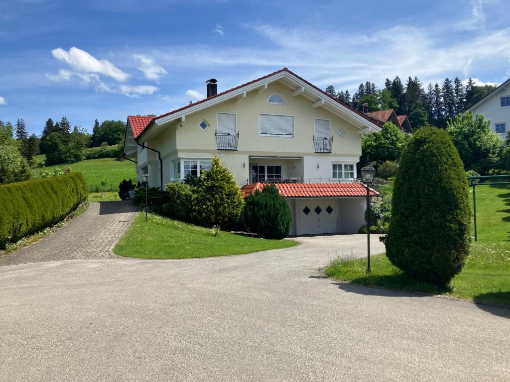 a large white house with a driveway at Landhaus am Bach in Sulzberg