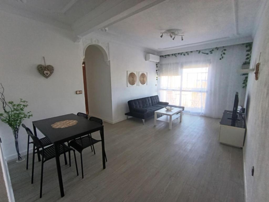 a living room with a table and a couch at Sevilla Gateway a 10 min Sevilla y cerca aeropuerto, 3 habitaciones, 2 camas en cada habitación y sofá cama in Alcalá de Guadaira