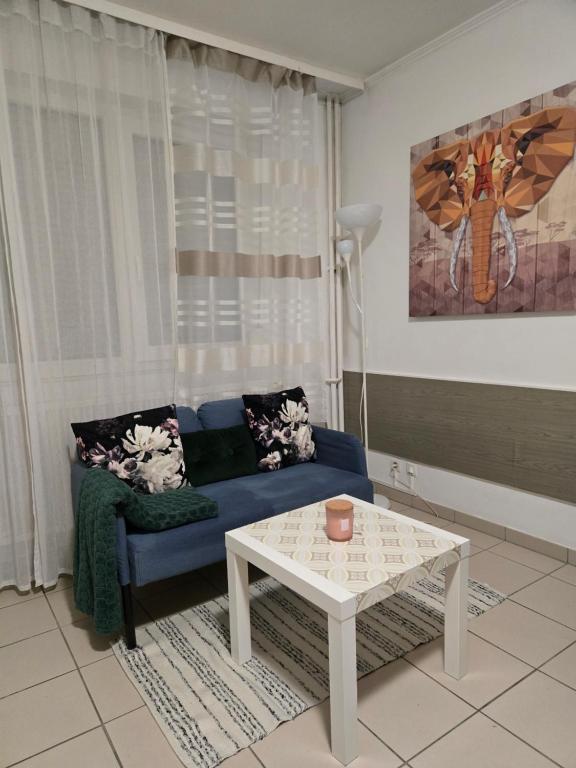 a living room with a blue couch and a table at Studio 110 pres Basel Airport in Saint-Louis