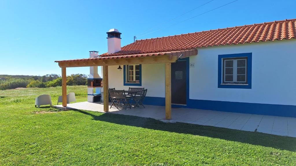a small blue and white house with a table at Monte Sardão in Cavaleiro
