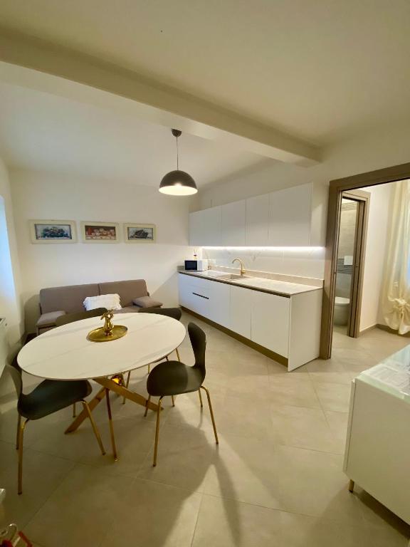 a kitchen and a table and chairs in a room at Maison Federica in Colà di Lazise