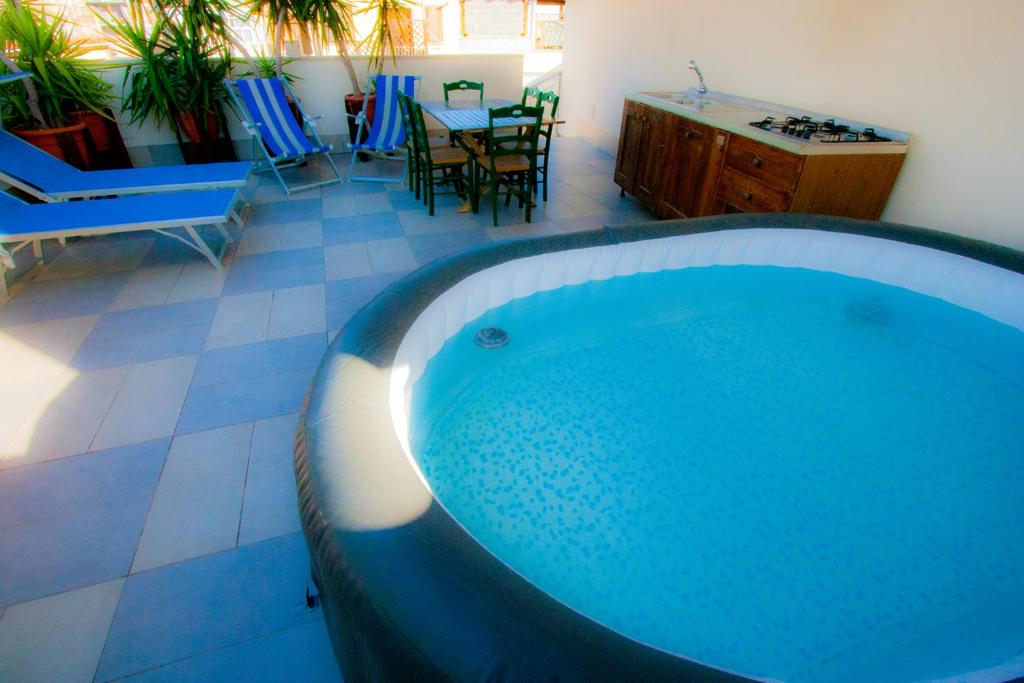 a large bath tub in a room with a table and chairs at Old Style by the sea, roof terrace with pool and kitchen, Ladispoli in Ladispoli