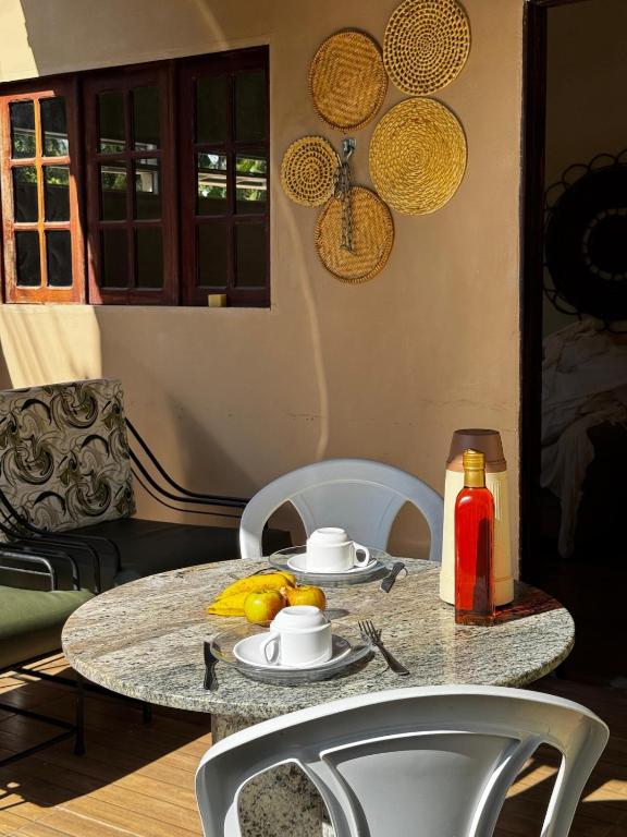 a table with chairs and a ketchup bottle on it at Casa Aconchego do Mar in Japaratinga