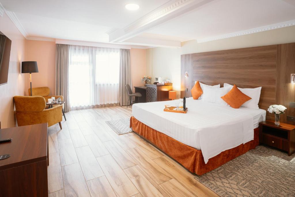 a hotel room with a large bed and a desk at Karen Plains Hotel Nairobi in Nairobi