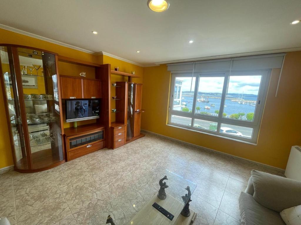a living room with a couch and a large window at A Riveira in Muxia