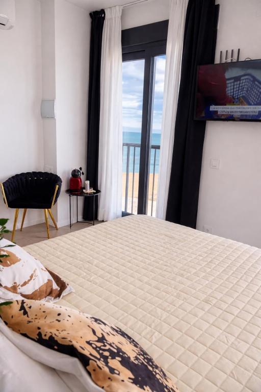 a bedroom with a bed with a view of the ocean at LUSAIL 1ª línea playa ADULTS ONLY in Vinarós