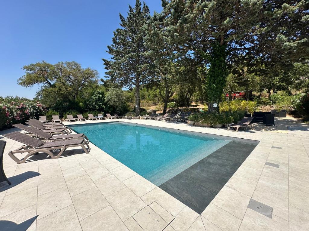 a swimming pool with chaises and lounge chairs next to it at Le Mas Saint Donat in Sainte-Maxime