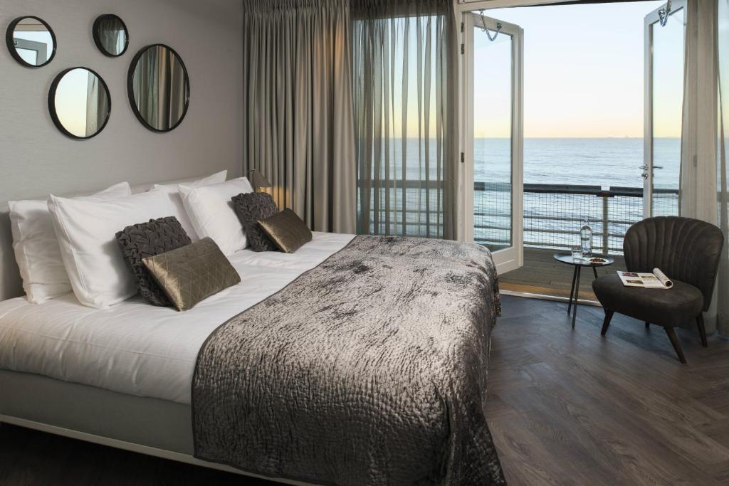 a bedroom with a bed with a view of the ocean at De Pier Suites in Scheveningen