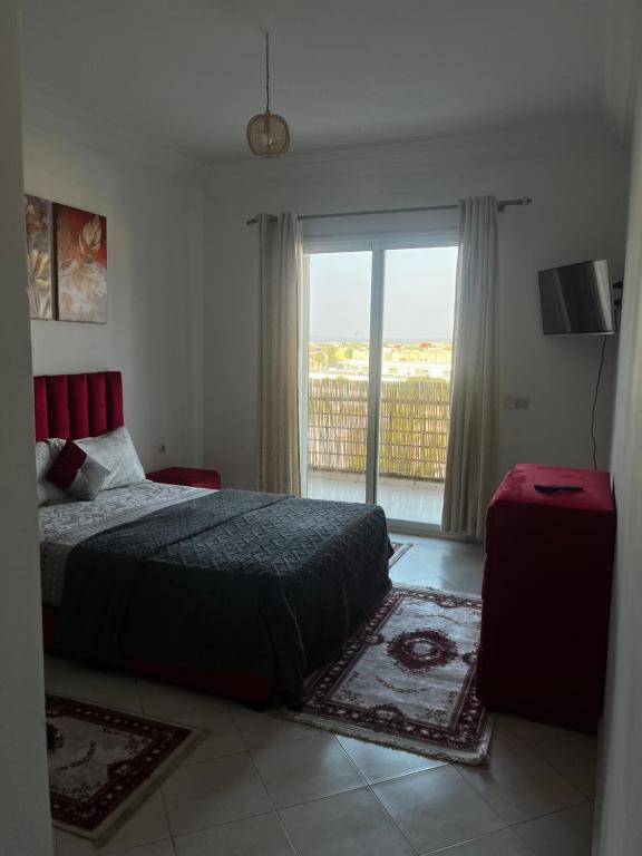 a bedroom with a bed and a sliding glass door at Appartement Moderne à coté de la plage - Essaouira in Essaouira