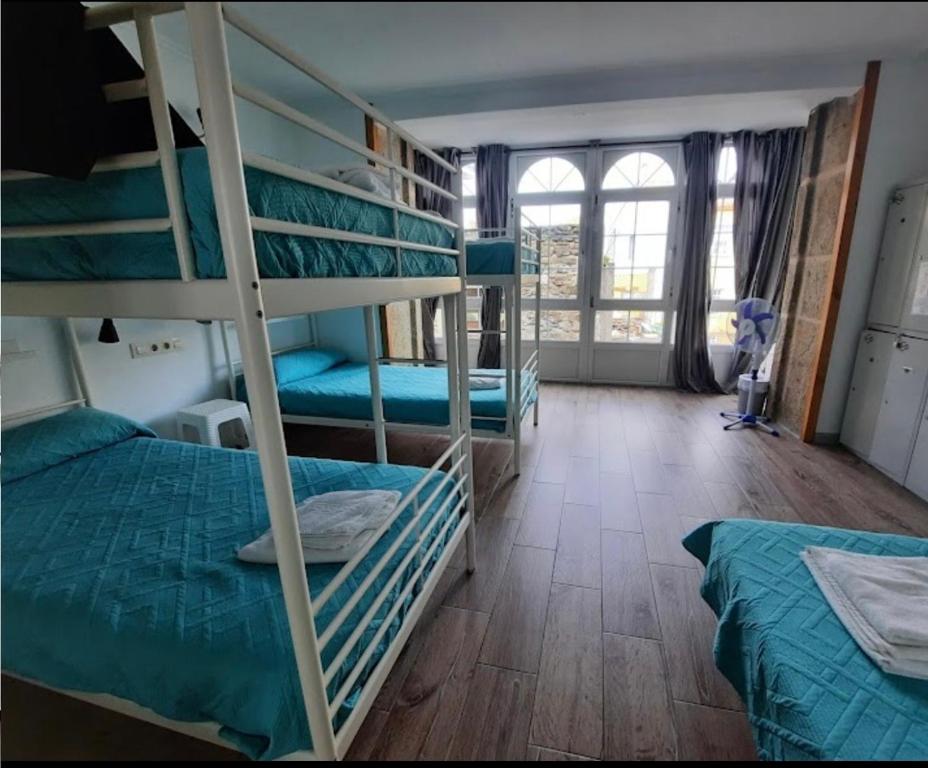 a room with two bunk beds and a window at Albergue Mar del Plata in Fisterra