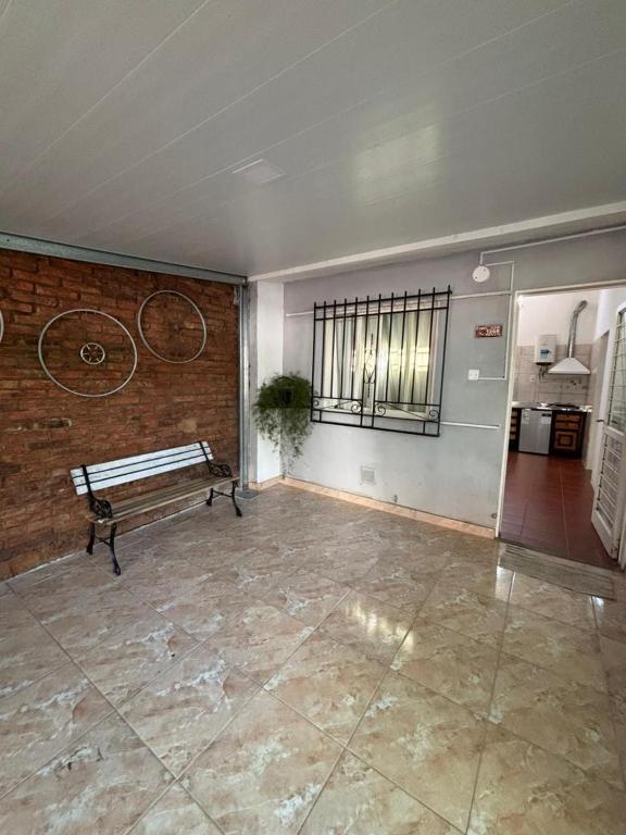 a empty room with a bench and a brick wall at Ciza - Departamento Temporario en Paraná in Paraná