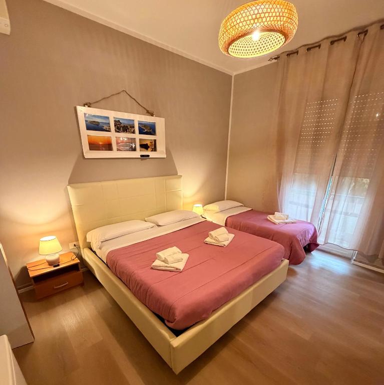 a bedroom with two beds and a chandelier at B&B Dora 2,0 in Praia a Mare