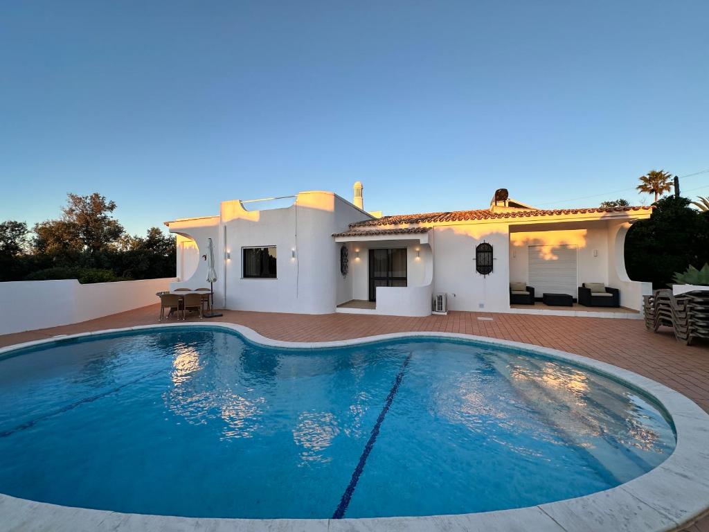a swimming pool in front of a villa at Villa Tara Christina in Carvoeiro