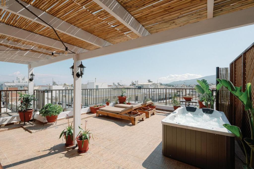 an outdoor patio with a hot tub on a roof at Skyloft - Rooftop Jacuzzi & Sea View - Central Kos in Kos