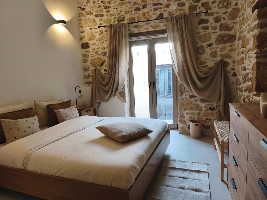 a bedroom with a large bed and a window at ARETOUSA Private Village Suite in Sitia