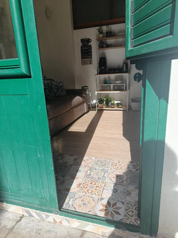 a living room with a green door and a tile floor at Casetta d'Ossuna in Palermo