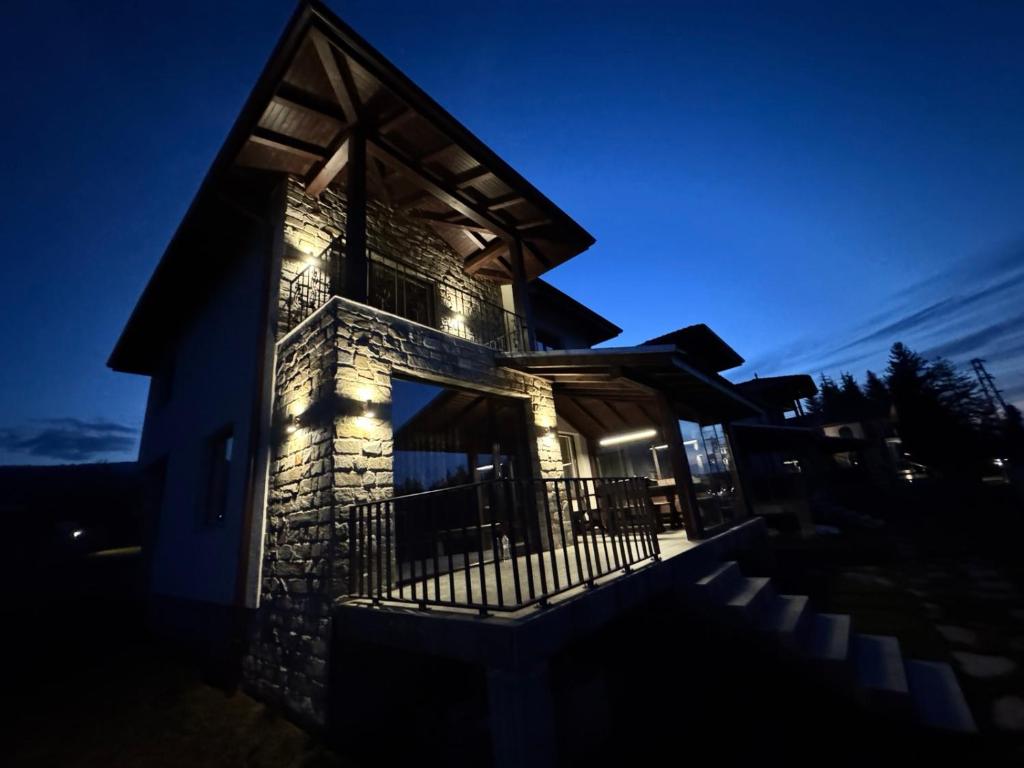 a house with lights on the side of it at night at Guest houses Forte in Tsigov Chark
