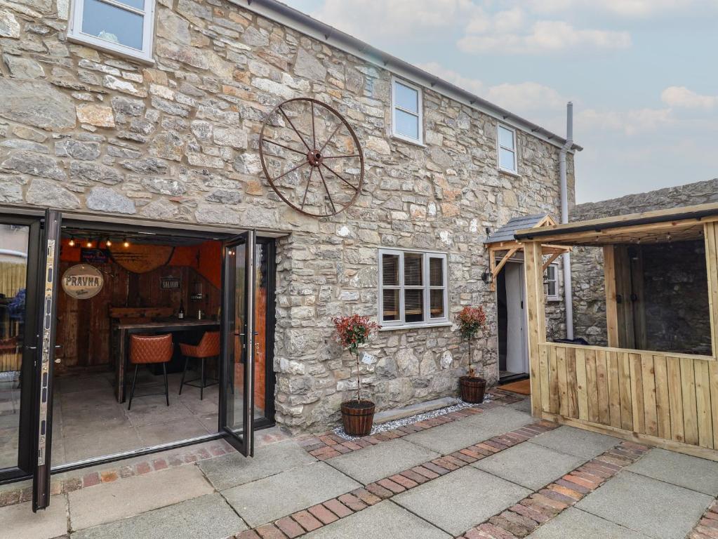 a stone house with sliding glass doors and a patio at The Ranch in Prestatyn