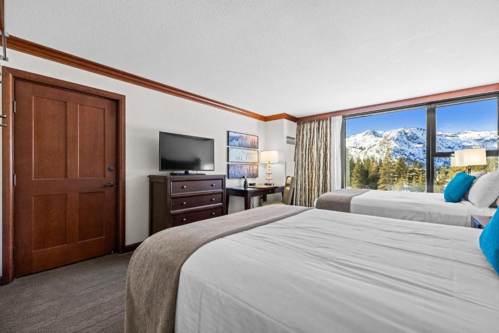 a hotel room with two beds and a television at Olympic Valley Summer Stay: Everline Resort & Spa! in Olympic Valley
