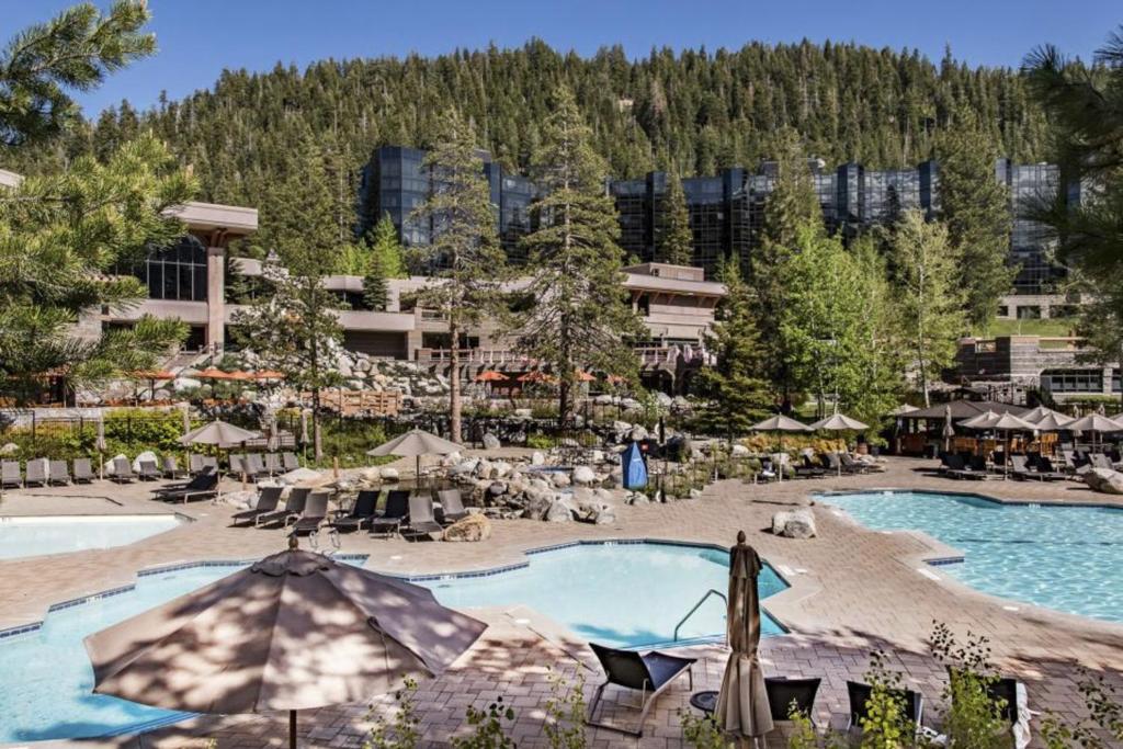 a resort with two pools and umbrellas at Resort Perks! Everline Corner Retreat w/ 3 Units in Olympic Valley