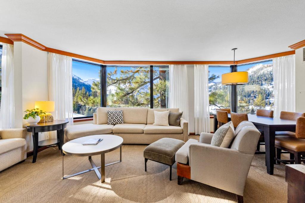 a living room with a couch and a table and some windows at Pool, Hot Tub & Golf: Everline Resort Corner Suite in Olympic Valley