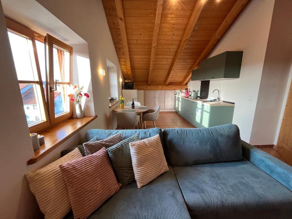 a living room with a blue couch with pillows at Heidis Ferienwohnung Abendlicht in Egling
