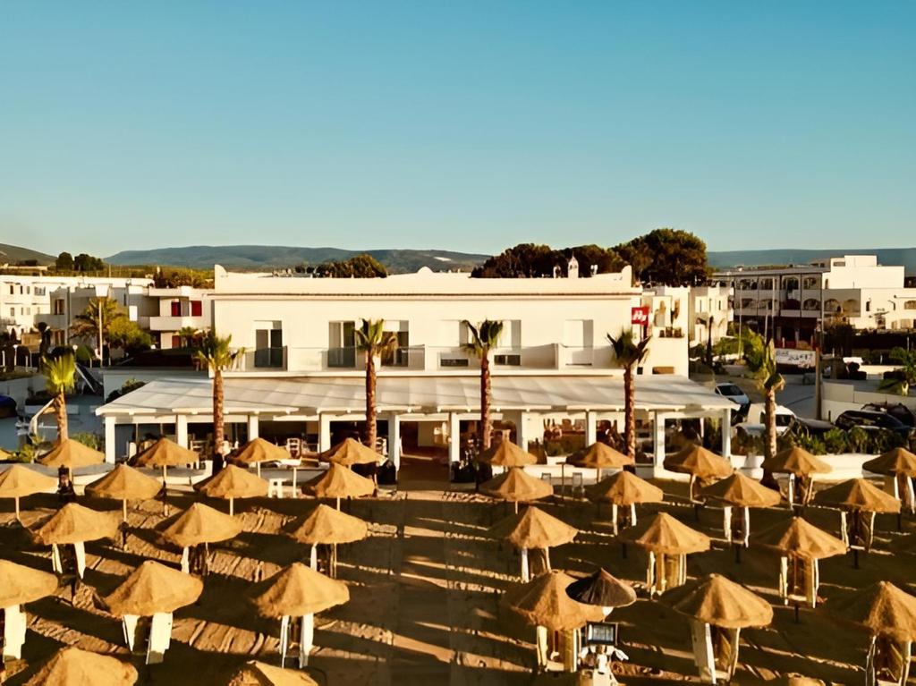 a group of umbrellas in front of a building at Albergo Diomedee Rooms on the Beach in Rodi Garganico