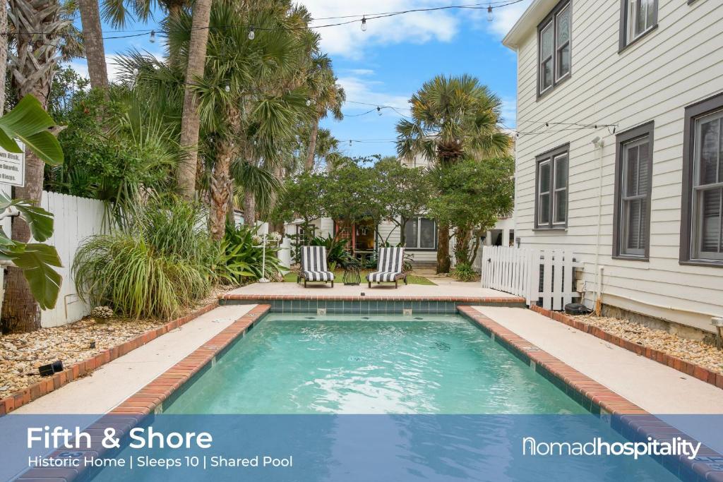 a swimming pool in a yard next to a house at Be A Nomad - 4 Bedroom Historic House - Pool -1 Block Jacksonville Beach in Jacksonville Beach