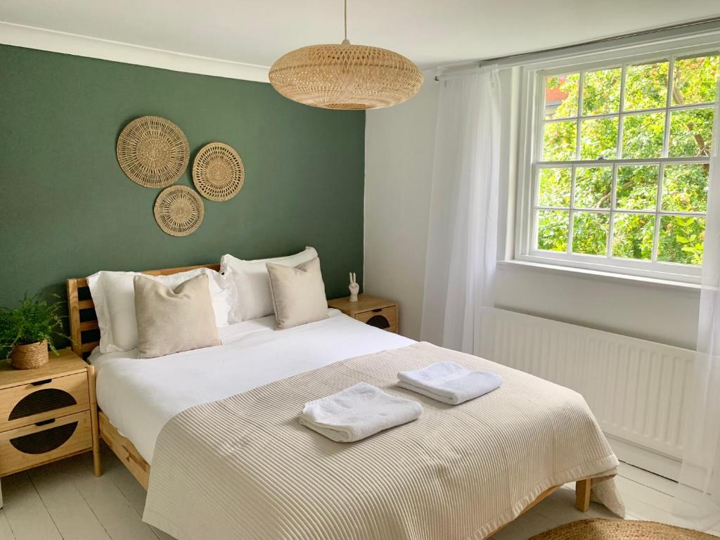 a bedroom with a white bed with two towels on it at Richmond Escape in Richmond upon Thames