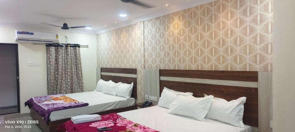 a hotel room with two beds and a tv at HoTEL SRI DURGA GRAND in Vijayawāda