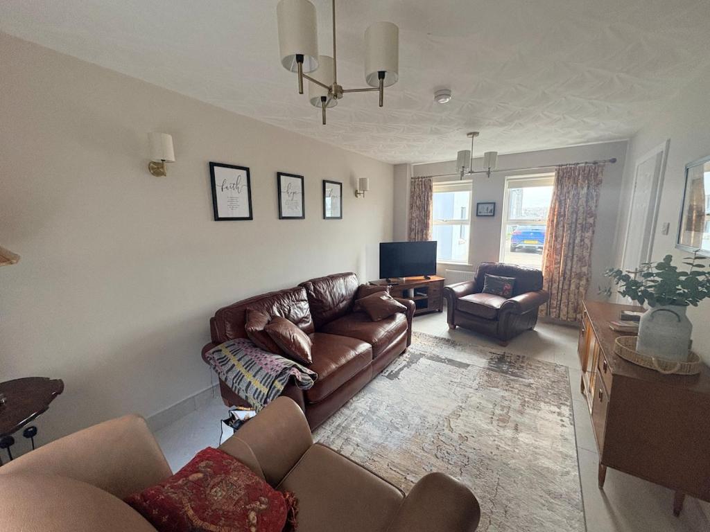 a living room with a couch and a tv at Bide A While at the Port in Portrush