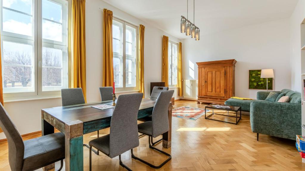 a living room with a table and a couch at Fürstlich Wohnen am Circus mit Blick zur Granitz in Putbus