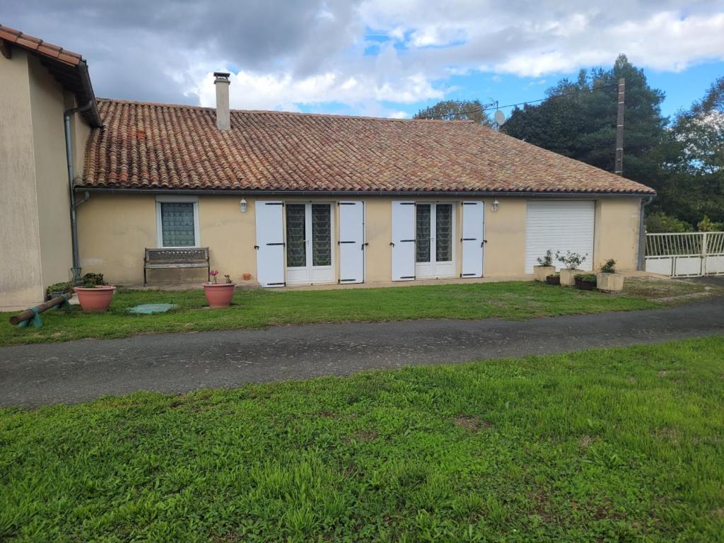 a small yellow house with a grass yard at Gîte de La Rev'rie in Montalembert