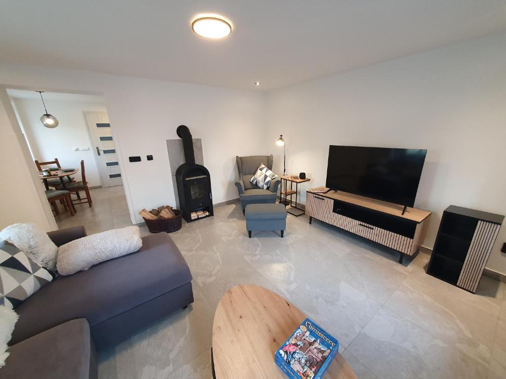 a living room with a couch and a tv at Domov na cestě in Rousovice