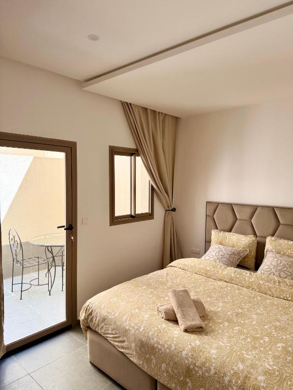 a bedroom with a bed and a balcony with a table at SOHO Rooftop 360 Sunset Edition in Essaouira