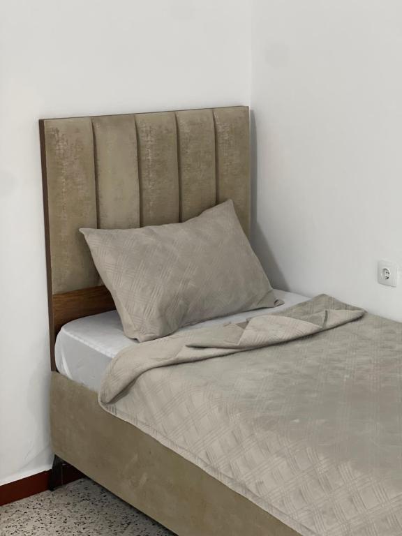 a bed with a headboard and a pillow on it at Hotel grosvenor in Saint-Arnaud