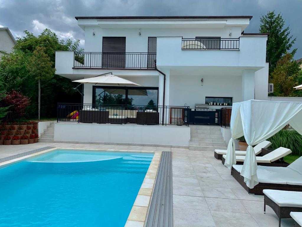 a villa with a swimming pool and a house at Theodora Residence in Balatonalmádi
