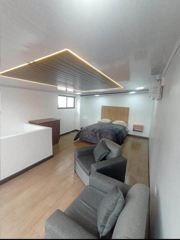 a living room with a bed and a couch at Duplex de la Sucre in Loja