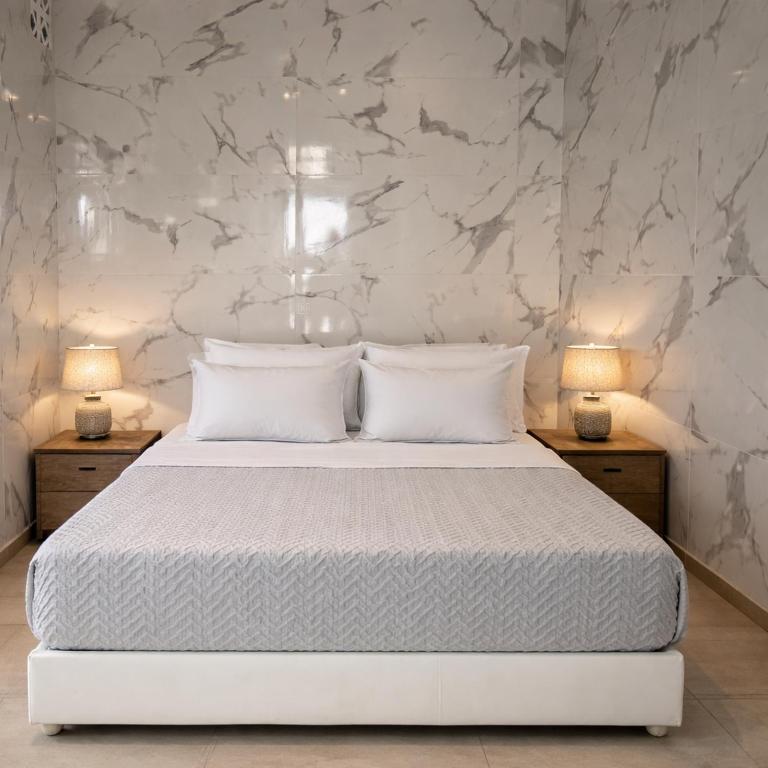 a bedroom with a white bed with two lamps at Mykonos Port Apartment in Tourlos