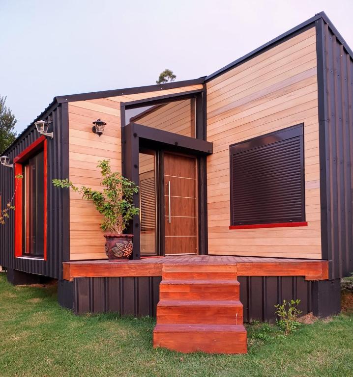 a tiny house with a front door and a deck at Pinot Noir in Piriápolis