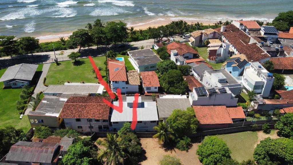 an aerial view of a house with a red arrow at Casa na praia prática aconchegante in Serra